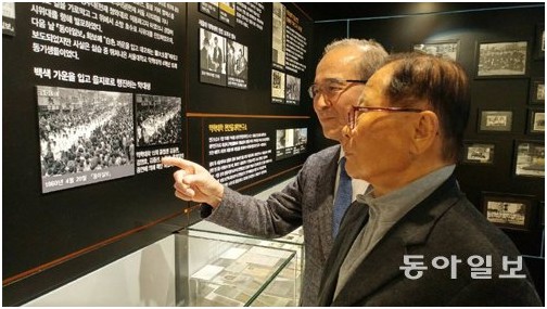 13일 서울 관악구 서울대 약학대 가산약학역사관을 찾은 박정식 씨(앞쪽)와 김한주 씨. 57년 전 4월 19일을 떠올리며 당시 동아일보에 실렸던 거리 행진 사진을 손으로 가리키고 있다.