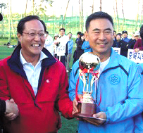 최두주 단장이 전국약사축구대회에서 우승 트로피를 들고 있다. 사진 왼쪽은 민병림 당시 서울시약사회장.