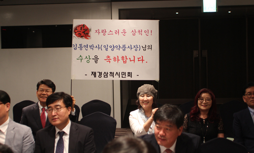 김 이사장의 수상을 축하하기 위해 시상식장을  찾은 재경삼척시민회 회원들이 축하피켓을 들고 환호하는 모습.
